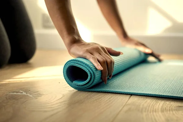 Mujer Enrollando Una Esterilla Yoga — Foto de Stock