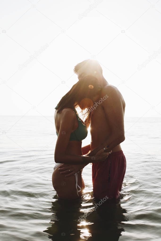 Romantic couple in the sea at sunset