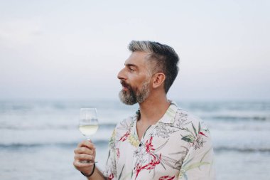 Adam sahilde bir kadeh şarap içmek