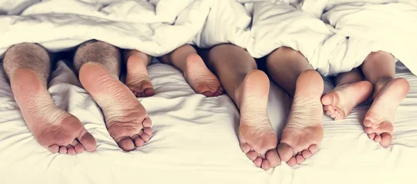 Όλη Οικογένεια Μοιράζονται Κρεβάτι Πόδια Κάτω Από Την Κουβέρτα — Φωτογραφία Αρχείου