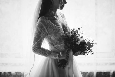 Bir buket çiçek tutan çekici güzel genç gelin