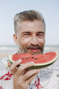 Olgun man yemek karpuz sahilde