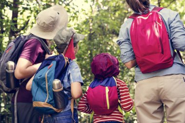 Arkadan Görünüş aile yürüyüşçü üzerinde uzak ormanda seyir sırt çantaları ile