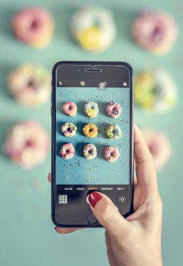 Kadın alarak fotoğraf Donuts ile hareket eden telefon