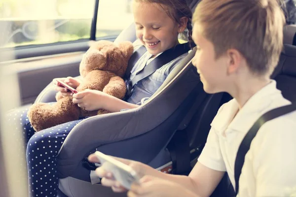 Little Sister Child Safety Seat Brother Playing Digital Devices Car — Stock Photo, Image