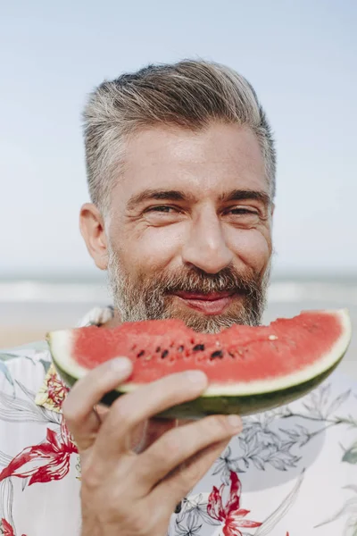 Olgun man yemek karpuz sahilde