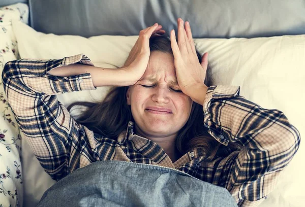 女性睡眠障碍问题的高级视图躺在床上 抱着她的头 — 图库照片