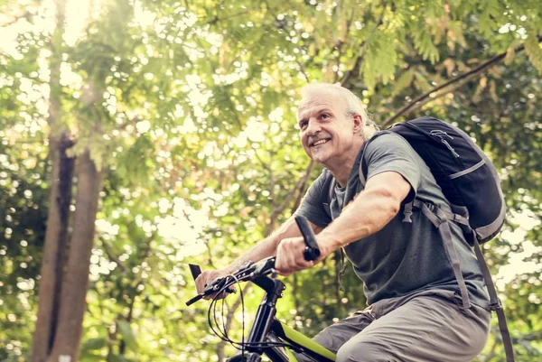 Parkta bisiklet ve gülümseyen kıdemli adam 