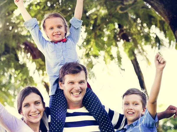 Aile parkı ve eller yukarı, baba omuzlarında oturan kızı eğleniyor