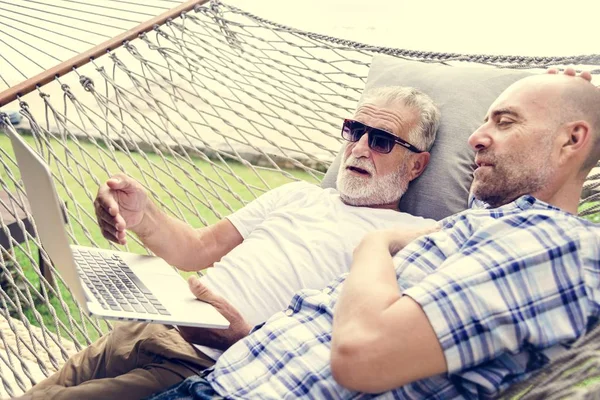 Senior Mannen Liggend Een Hangmat Met Behulp Van Een Laptop — Stockfoto