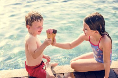 Havuz kenarındaki, kremler ile toasting çocuklar buz