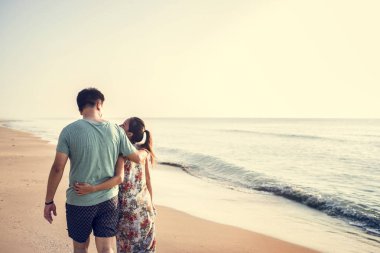 Kumsalda yürüyen çift.