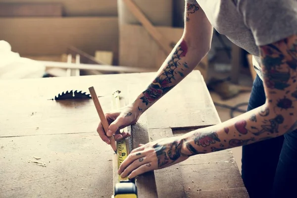 木材に鉛筆と測定テープを使用して入れ墨をした女性大工の部分的なビュー — ストック写真