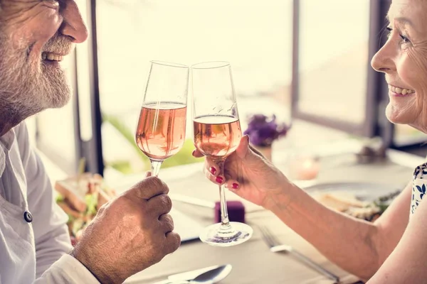 Casal Sênior Alegre Bebendo Champanhe Rosa — Fotografia de Stock