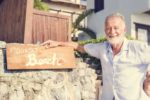 Resort işaretiyle ayakta olgun adam