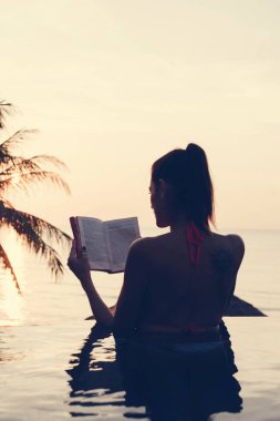 Kadın yüzme havuzunda bir kitap okuma