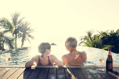 Üst düzey çift bir yüzme havuzunda prosecco içme