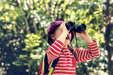 Küçük kız ormanda dürbün seyir