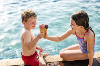 Havuz kenarındaki, kremler ile toasting çocuklar buz