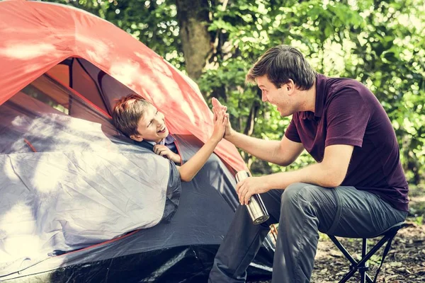 Çadırdan dışarı yaslanmış ve beş babası ormandaki veren küçük çocuk