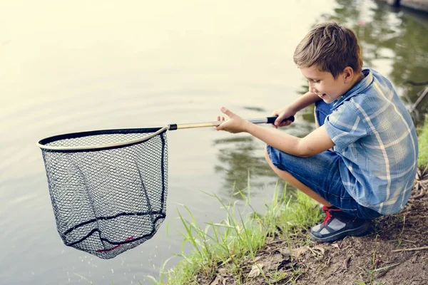 Net ile nehir balıkçılık tarafından çocuk çömelmiş