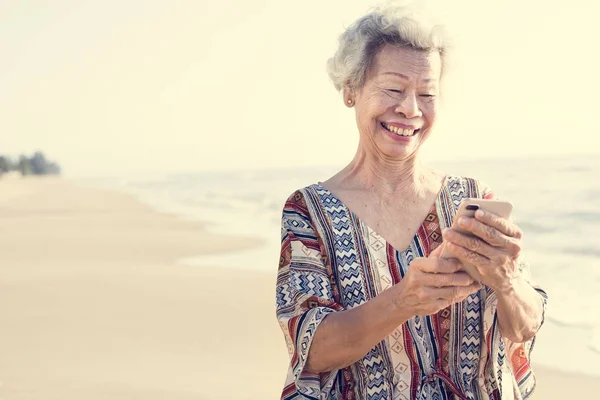 Senior Asian Kobieta Przy Użyciu Telefonu Plaży — Zdjęcie stockowe