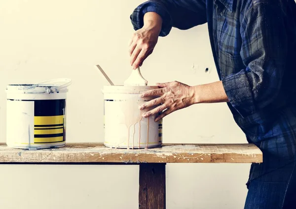 Trabajador mezclando pintura en cubo — Foto de Stock