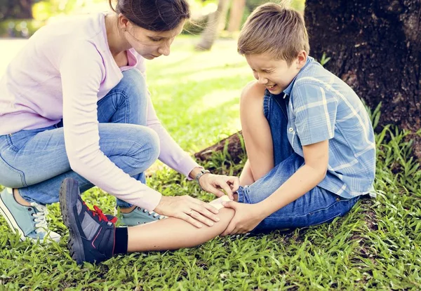 Küçük çocuk, anne oğul bacakta alçı yapıştırma oynarken bacağını alıntı