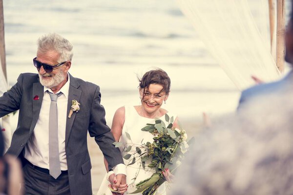 Youthful mature couple getting married at the beach