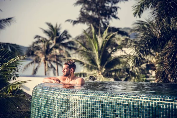 Yakışıklı adam yüzme havuzunda rahatlatıcı