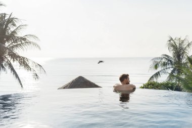 Yakışıklı adam yüzme havuzunda rahatlatıcı