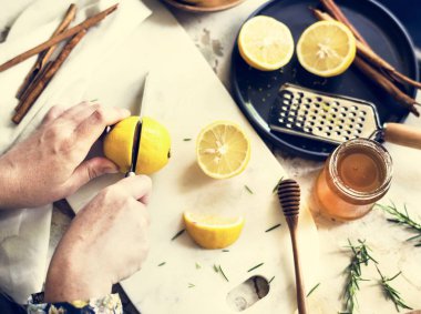 Bıçakla limon kesen ellerin havadan görünüşü