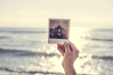 Yaşlı kadın bir fotoğraf vasıl belgili tanımlık kıyı holding