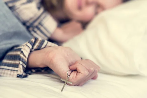 Joven Sonriente Pijama Cuadros Durmiendo Cama Con Cruz Católica Mano — Foto de Stock