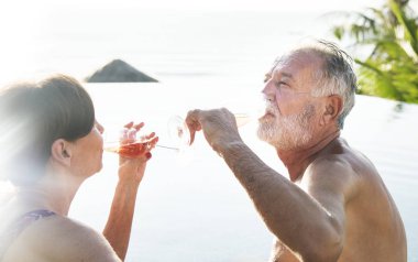 Üst düzey çift bir yüzme havuzunda prosecco içme