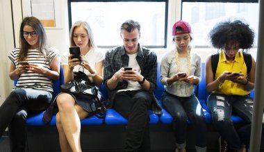 Akıllı telefonlar metroda kullanarak genç yetişkin arkadaş grubu