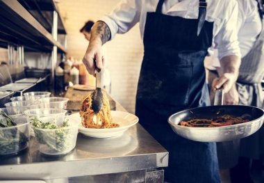 Şef mutfakta spagetti yemek