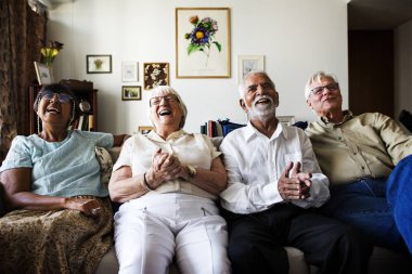 Grup üst düzey arkadaşıyla birlikte oturan ve birlikte tv izlerken