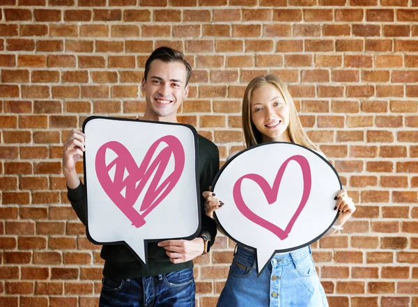 Konuşma balonları kalp ikonları ile tutarak mutlu genç çift
