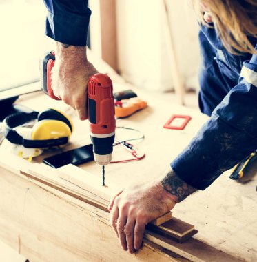 Constraktör tamircisi çalışıyor ve tornavida kullanıyor.