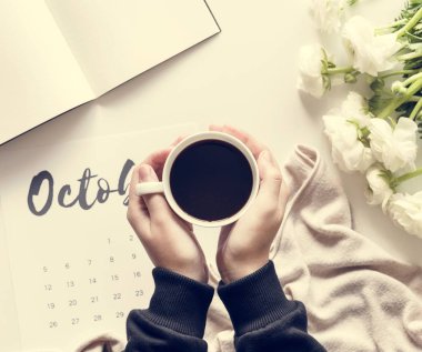 Kahve fincanı Ekim takvim ile masada tutan kadın 