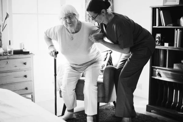 Krankenschwester Hilft Seniorin Beim Stehen — Stockfoto
