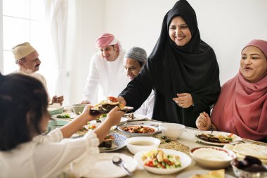 Muslim woman sharing food at Ramadan feast clipart