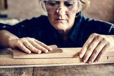 Marangoz bir ağaçla çalışıyor.