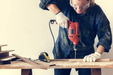 Constraktör tamircisi çalışıyor ve tornavida kullanıyor.