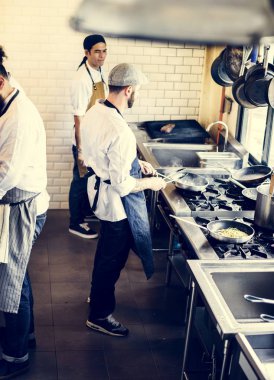 Şef lokanta mutfağında yemek pişiriyor.