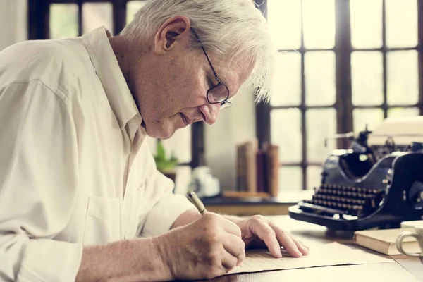 Elderly man writing a letter — Stock Photo, Image