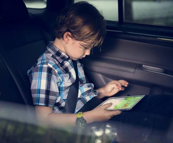 Юный Кавказский Мальчик Использующий Цифровые Планшеты Внутри Автомобиля — стоковое фото