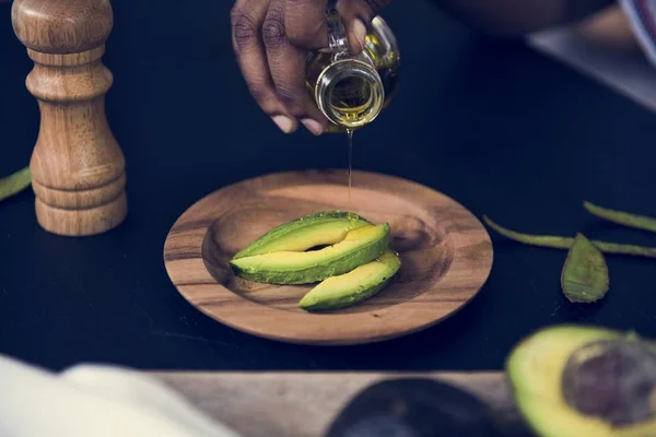 Closeup Fresh Avocado Wooden Plate Topping Olive Oil — Stock Photo, Image