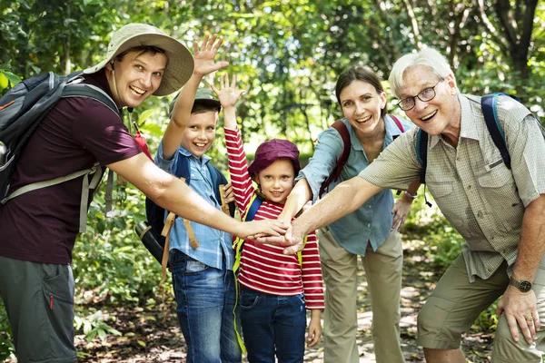 Family stacking hands as a team in forest